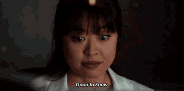 a woman in a lab coat says good to know in a dark room