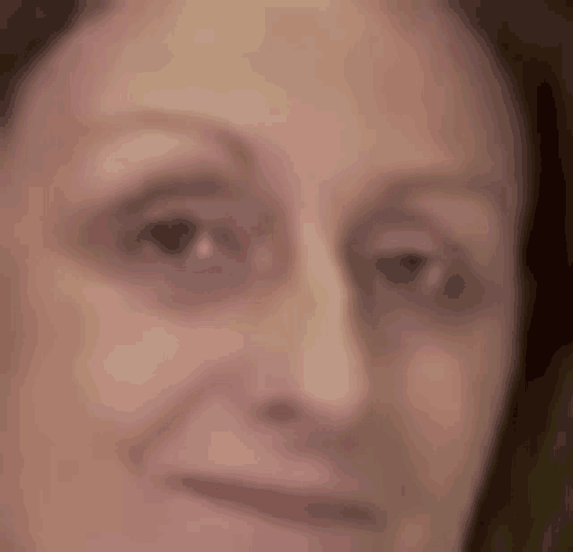 a close up of a woman 's face with a smile on her face .