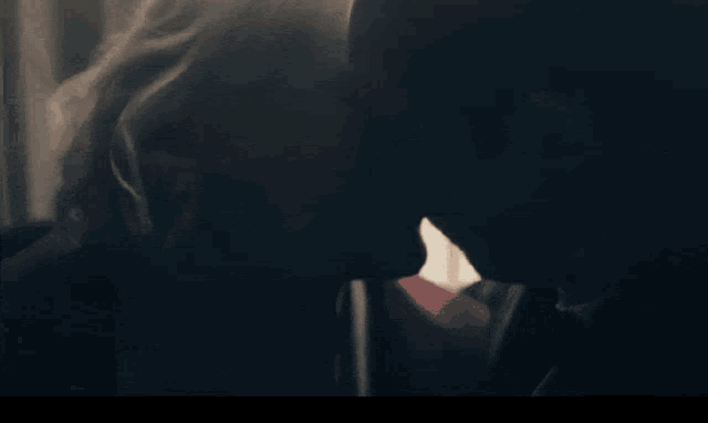 a man and a woman kissing in a dark room