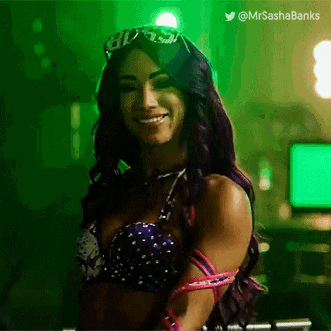 a woman wearing sunglasses and a bra is smiling in a green room .