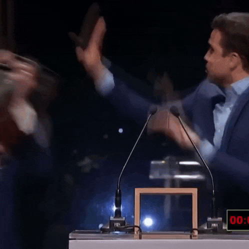 two men are fighting in front of microphones and a timer that says 00:00