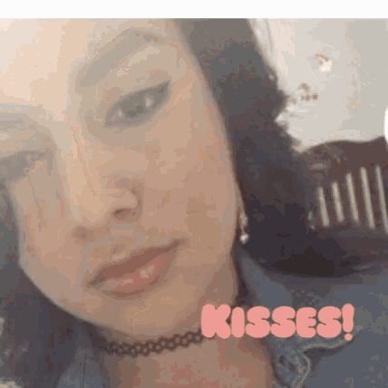 a close up of a woman 's face with the words kisses written in pink