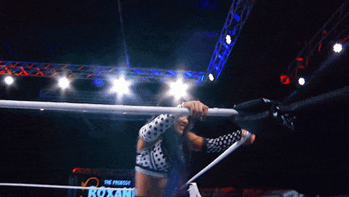 a female wrestler is standing in a ring wearing a polka dot outfit