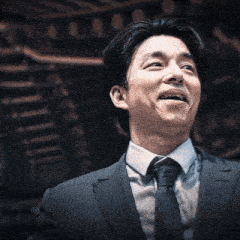 a man in a suit and tie is smiling in front of a staircase .