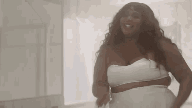 a woman in a white dress is standing in a bathroom .