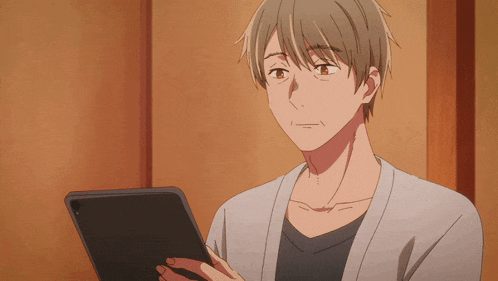 a man is holding a tablet in his hand and looking at it
