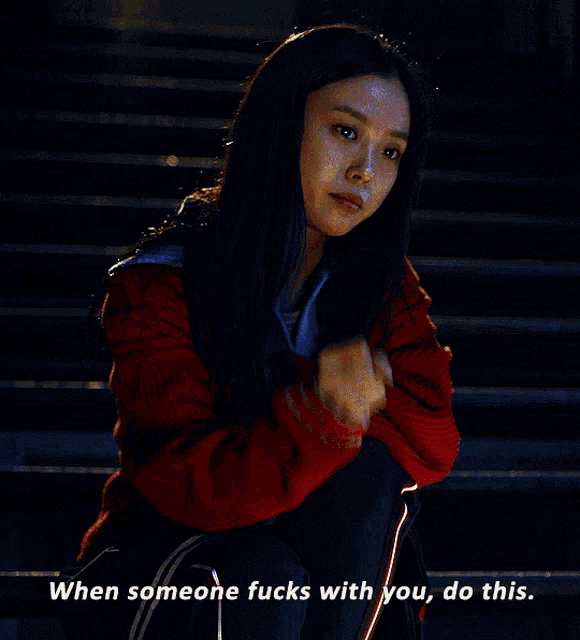 a woman in a red sweater gives the middle finger