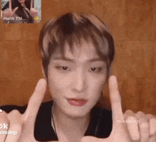 a young man is giving a thumbs up sign while talking to a woman on a video call .