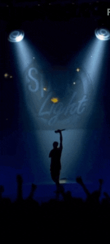 a man singing into a microphone in front of a sign that says ' sky light '