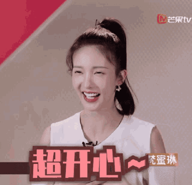 a woman with a ponytail is smiling in front of a sign with chinese characters on it