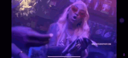 a woman is singing into a microphone at a party in a club .