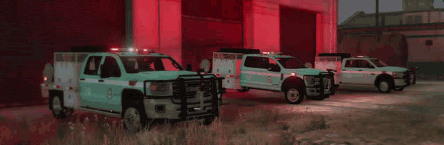 three emergency vehicles are parked in front of a red building