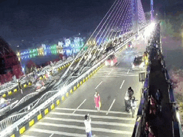 a bridge is lit up at night with people walking on it