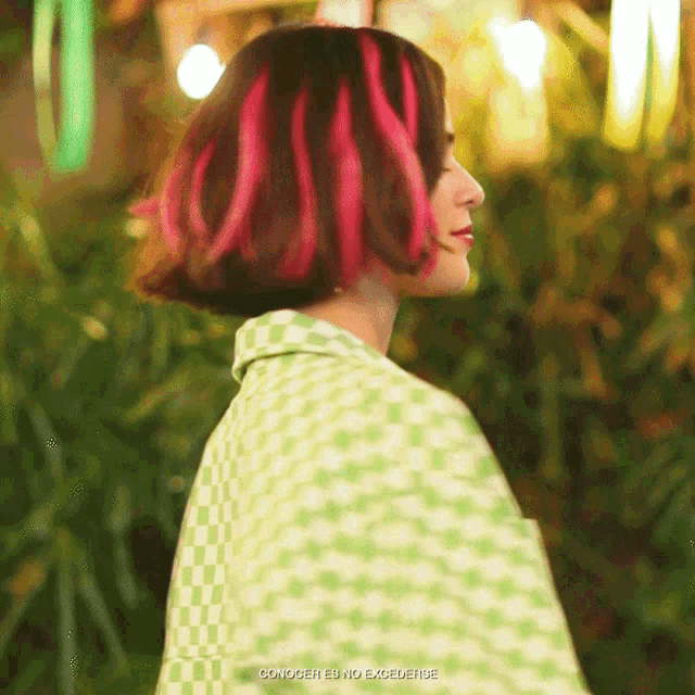 a woman with red hair is wearing a green checkered jacket