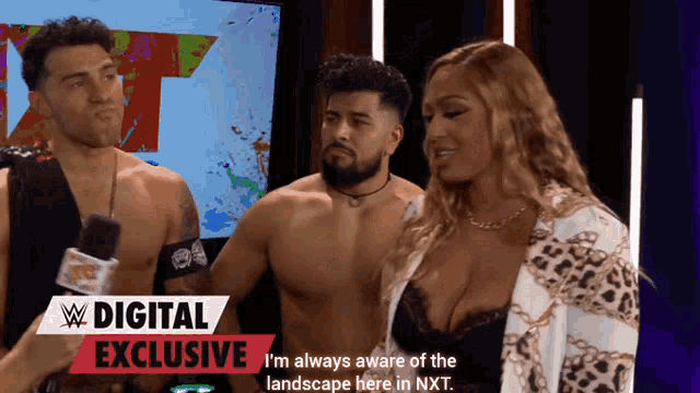 two men and a woman are standing in front of a sign that says ' digital exclusive '