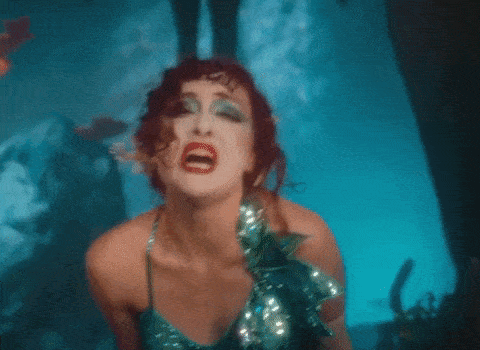 a woman in a mermaid costume is making a face