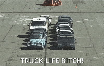 a bunch of cars are sitting on top of each other in a parking lot with the words `` truck life bitch '' .