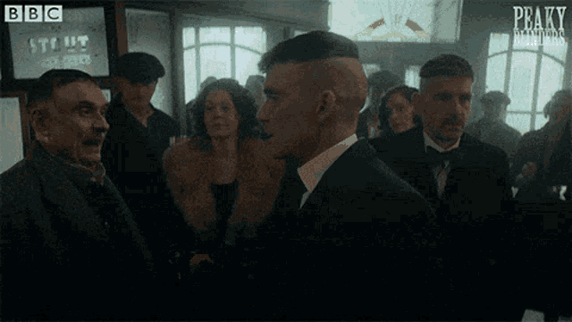 a group of people are standing in a room with the word peaky blinders written on the bottom