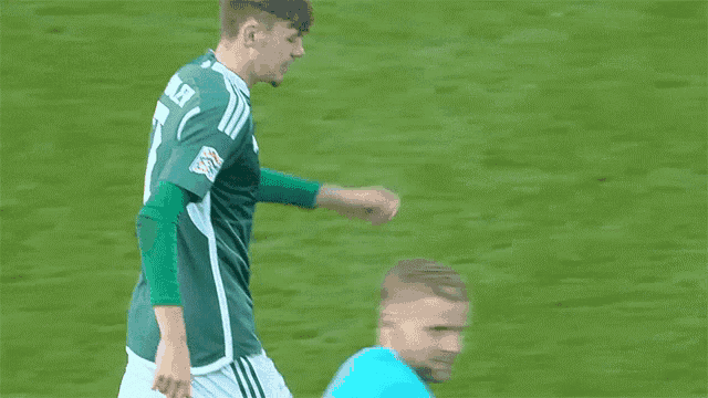 a soccer player wearing a green jersey with the number 2 on the front