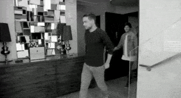 a black and white photo of a man and woman holding hands