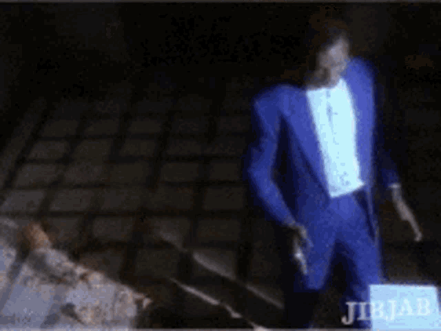 a man in a blue suit stands in front of a jib jab sign