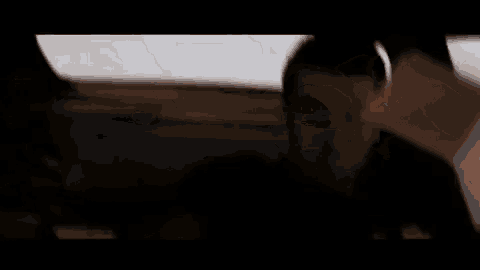 a man and a woman are sitting in a car talking on a phone .