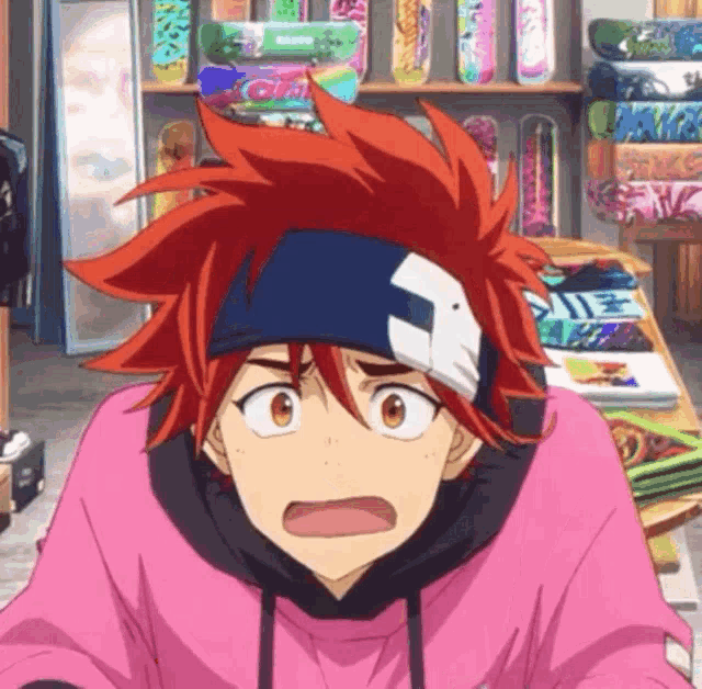 a boy with red hair and a bandage on his head is sitting in front of a skateboard display .
