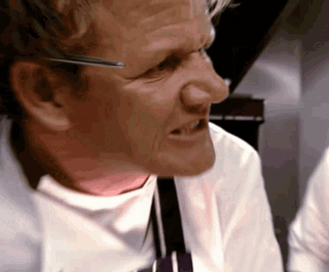 a close up of a man 's face with glasses and a tie
