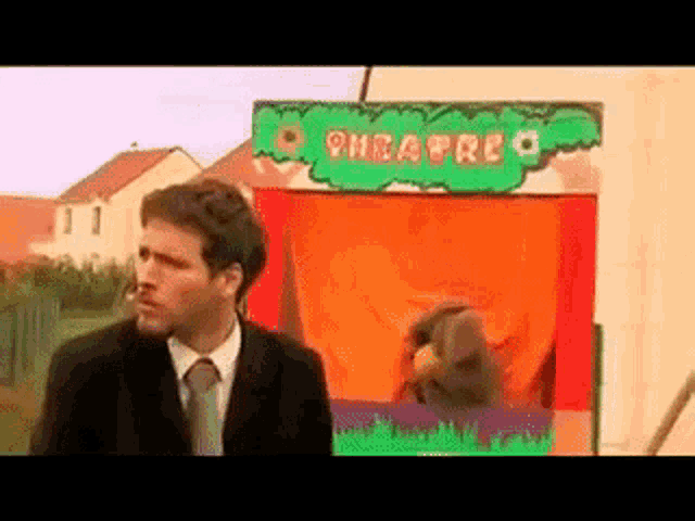 a man in a suit and tie stands in front of a sign that says pheafree