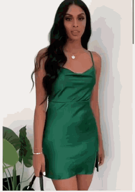 a woman is wearing a green satin dress .