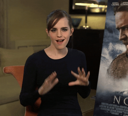 a woman sitting in front of a poster that says no on it