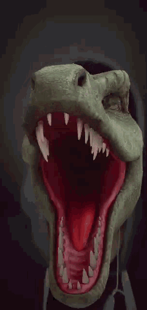 a person is wearing a dinosaur mask with their mouth open and teeth .