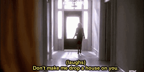 a woman is walking down a hallway with the words `` laughs '' written on the bottom .