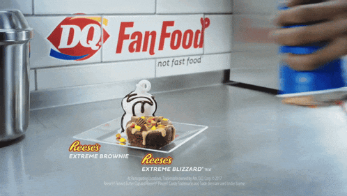 a reese 's extreme brownie on a plate in front of a dq fan food banner