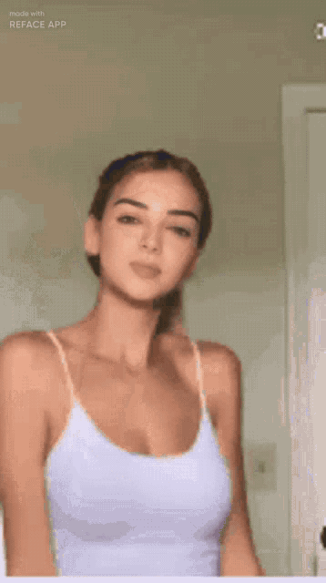 a woman wearing a white tank top is smiling and looking at the camera