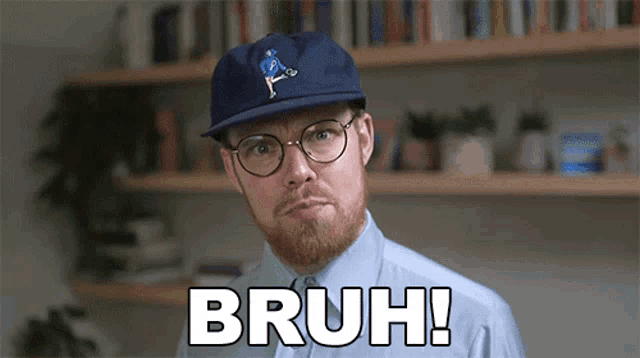 a man wearing glasses and a hat says bruh in front of a bookshelf