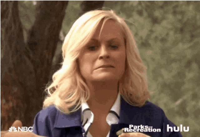a woman in a blue jacket with the words parks and recreation on the bottom right