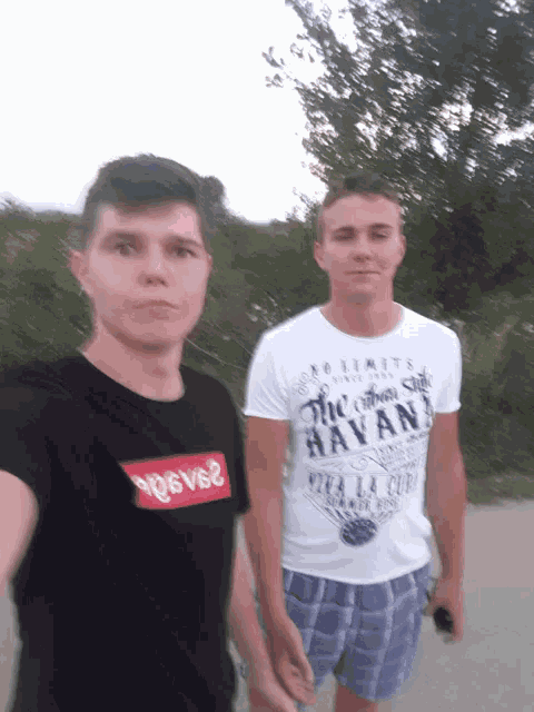 two young men standing next to each other one wearing a shirt that says havana