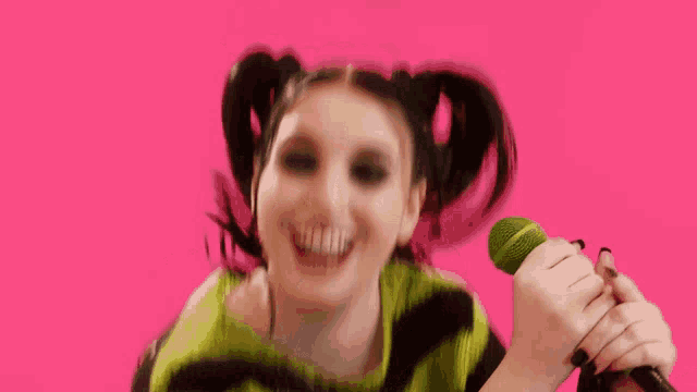 a woman with pigtails wearing a green and black sweater