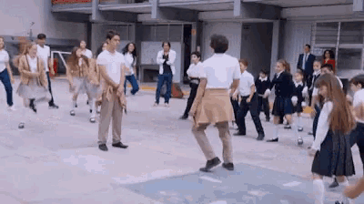 a group of children are dancing in a courtyard