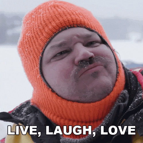 a man wearing an orange knitted hat with the words live laugh love on the bottom
