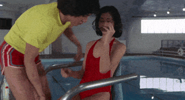 a man in a yellow shirt is talking to a woman in a red bathing suit