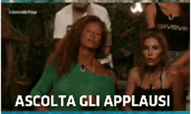 a woman in a green shirt is dancing in front of a group of people and the words ascolta gli applausi are above her