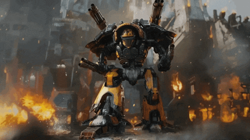 a large robot with a helmet on stands in front of a burning building