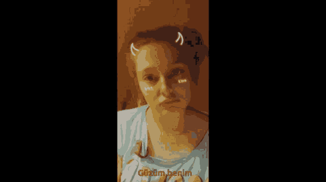a girl wearing a shirt that says " güzelim benim "