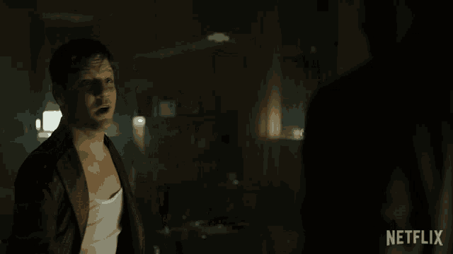a man is smiling in a dark room with a netflix logo on the bottom