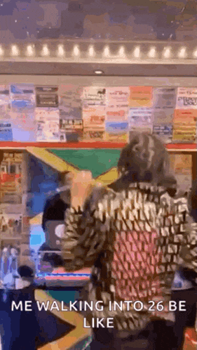 a woman in a leopard print jacket is walking into a 26 be like sign .
