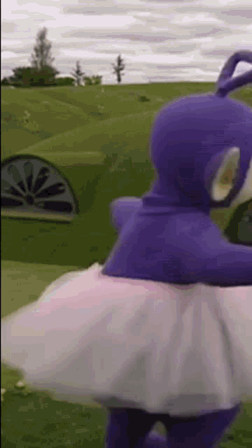 a purple teddy bear is wearing a white tutu and dancing .