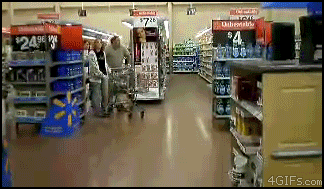 a man pushing a shopping cart in a walmart aisle