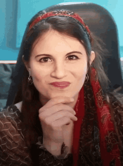a woman wearing a headband and scarf is making a face